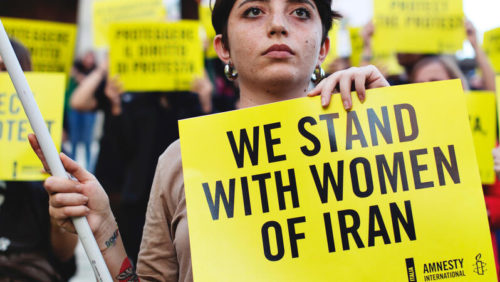 Das Bild zeigt eine Frau, die ein Schild in der Hand hält: "We stand with Women of Iran" Amnesty-Protest am 5. Oktober 2022 in Rom für die Rechte von Frauen im Iran © Amnesty International Italien, Foto: Francesca Maceroni
